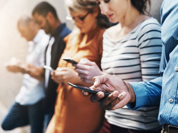 Five people using their smartphones