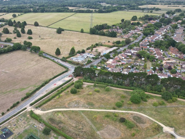 An aerial image of a crossroads at the edge of a settlement