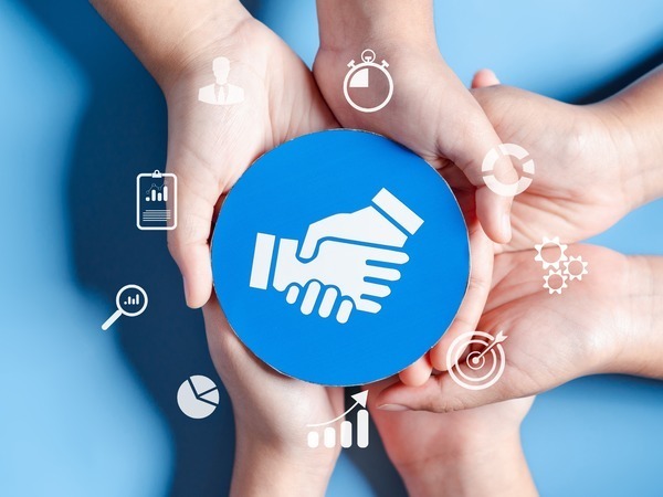 Hands holding a handshake icon surrounded by business symbols
